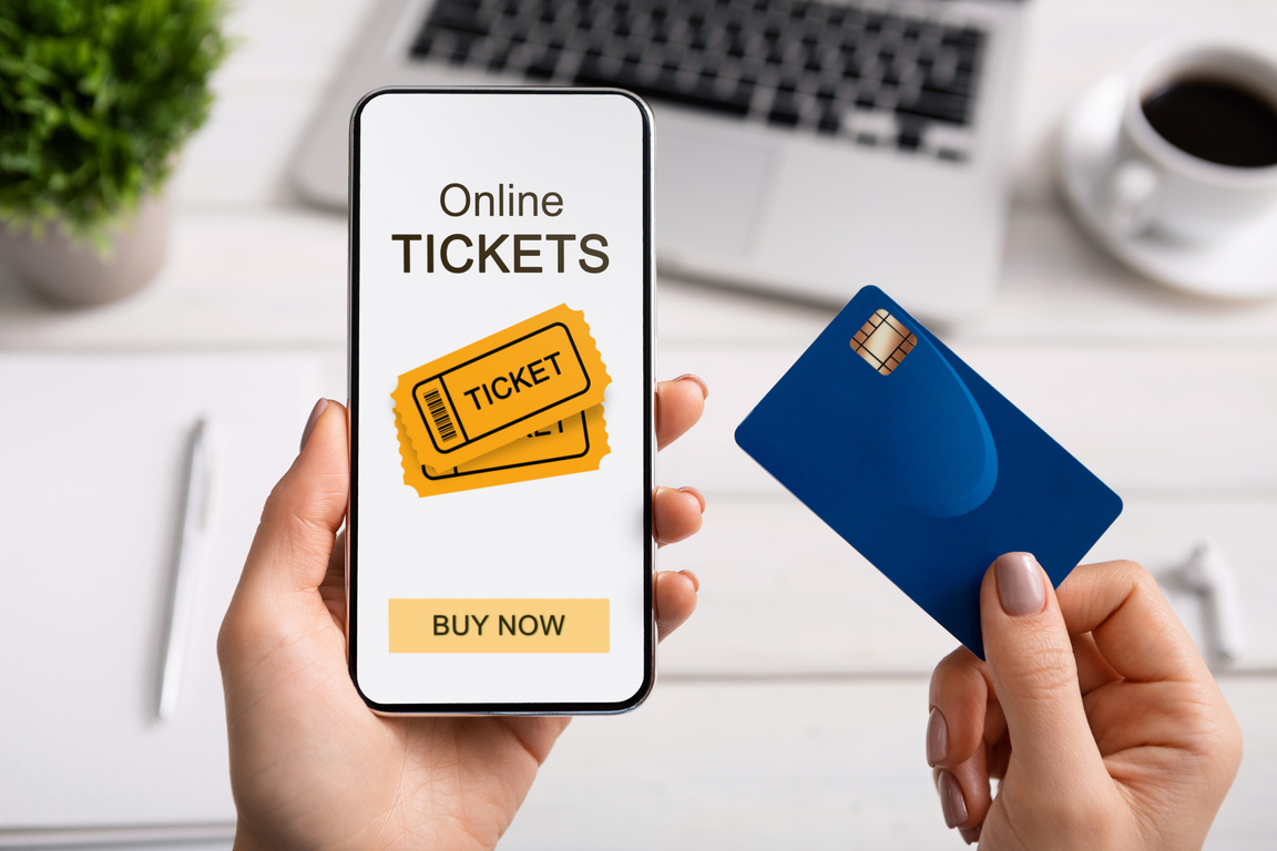 Woman holding smartphone with online tickets app and credit card